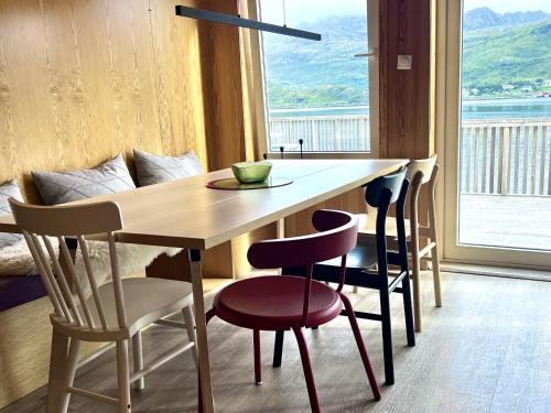 a dining room table with chairs and a large window at Fjordview Ryten 1 Retreat in Sund
