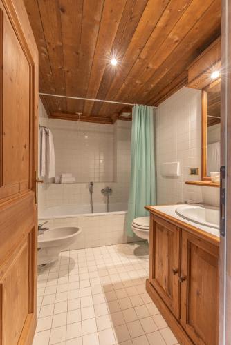 a bathroom with a tub and a toilet and a sink at Casa Crignes, residenziale a due passi dal centro in Cortina dʼAmpezzo