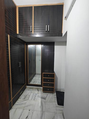 a hallway with black cabinets and a marble floor at Sukoon by Tajinder in Sohāna