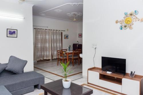 a living room with a couch and a tv and a table at Sukoon by Tajinder in Sohāna