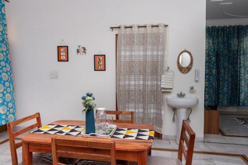 a dining room with a table and a bathroom at Sukoon by Tajinder in Sohāna