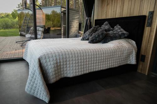 a bed with a white comforter on top of it at Torgu Kuningriigi palee in Rahuste