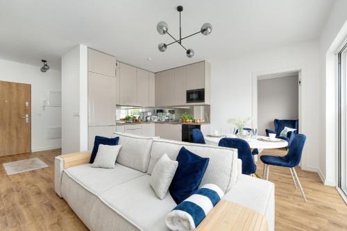a living room with a white couch and a table at Apartament na Brzozowej in Międzywodzie