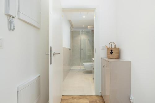 a white bathroom with a toilet and a shower at Apartament na Brzozowej in Międzywodzie