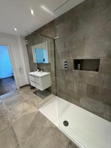 a bathroom with a glass shower and a sink at Spacious 4 beds house with FAST WIFI and FREE PARKING ideal for businesses, visiting family or relocation in Hatfield