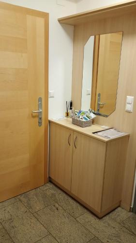 a bathroom with a vanity with a mirror and a door at SeeSternchen in Faak am See