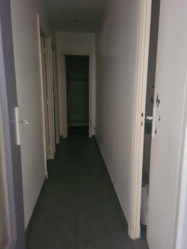 un long couloir avec des murs blancs et un sol vert dans l'établissement Appartement entre le velodrome et les plages!!!, à Marseille