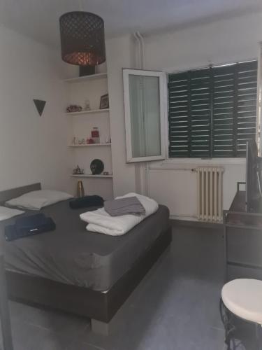 une chambre avec un lit, une table et une fenêtre dans l'établissement Appartement entre le velodrome et les plages!!!, à Marseille