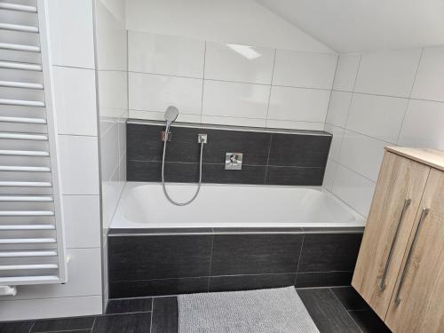 a bathroom with a bath tub with a shower at Apartment Eichhof in Innsbruck