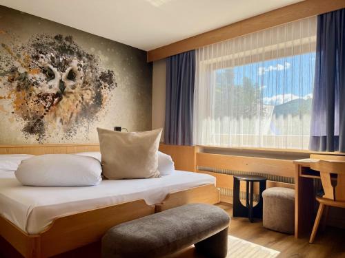 a hotel room with two beds and a window at Wellness Residence Panorama - check-in at Olympia Hotel in Arabba