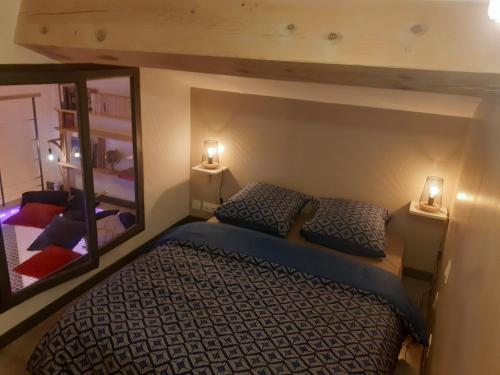 a bedroom with a bed with two lamps and a mirror at Charmante maison atypique in Régusse