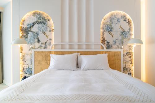 a bedroom with a white bed with two archways at Qlusive Hotel in Kusadası
