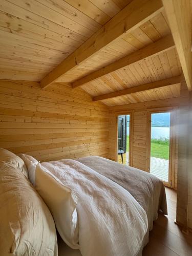 una camera da letto con un letto in una stanza di legno di Lakeside Glamping a Vossevangen
