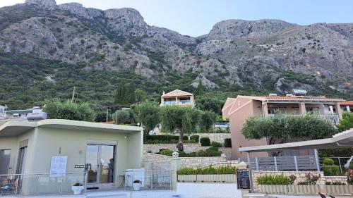 a building with a mountain in the background at Locanda Barbati Luxury ApartHotel in Barbati