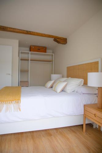 a bedroom with a large white bed with white pillows at TxOKO ETXEA in Bermeo