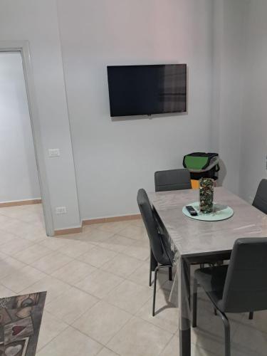 a dining room with a table with chairs and a tv at 40 Parallelo in Castel Volturno