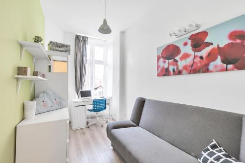 a living room with a couch and a desk at Fabryczna Station Rooms and Apartments in Łódź