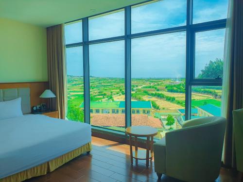 a hotel room with a bed and a large window at Muong Thanh Holiday Ly Son in Ly Son