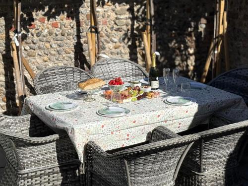 a table with a plate of food and a bottle of wine at Luxury Georgian home, hot tub, sea view, private garden, sleeps 6 in Bognor Regis