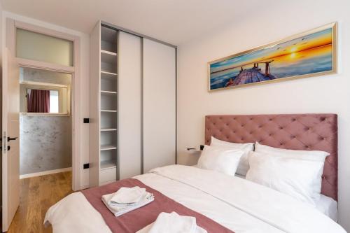 a bedroom with a large white bed and a window at Apartman 51 Sarajevo in Donje Mladice