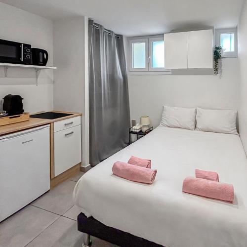 - une chambre avec un lit et 2 serviettes roses dans l'établissement Studio lumineux et moderne à Nice, bien situé, à Nice