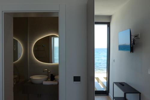 a bathroom with a sink and a mirror at Adria Resort SEAFRONT Villa C Private Pool Pet Friendly in Zaton