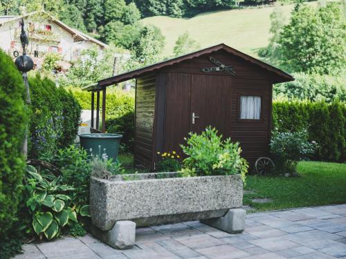 a small shed with a stone planter in front of it at NEW! Chalet Carina by we rent in Zell am See