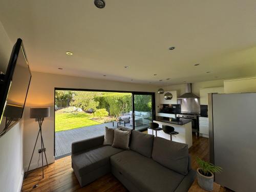a living room with a couch and a kitchen at Spacious 4 beds house with FAST WIFI and FREE PARKING ideal for businesses, visiting family or relocation in Hatfield