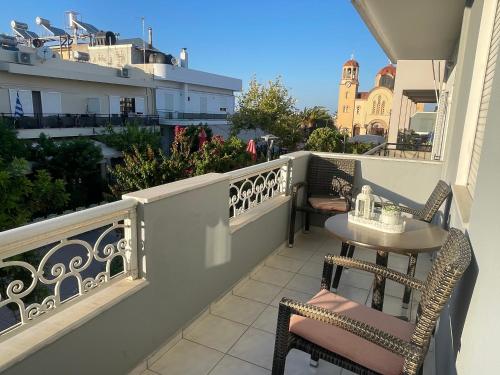 a balcony with two chairs and a table on it at The Obsidian Suite , next to Heraklion Airport in Heraklion