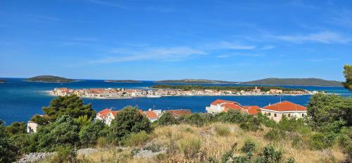 a view of a town on a body of water at Apartmani Deniza 2 guests in Brodarica
