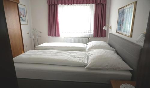 two beds in a bedroom with a window at Ferienwohnung in Gamlitz