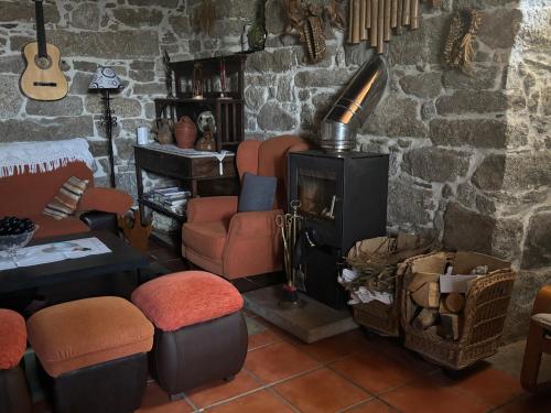 a living room with a wood stove and chairs at Albergue Rectoral de Romean in Lugo