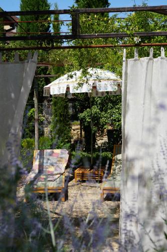 un patio avec un parasol, des chaises et une table dans l'établissement Santolina Etrusca Bed and Breakfast, Sauna, Hammam, Jacuzzi, à Rouffach