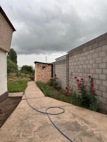 a hose on a sidewalk next to a brick wall at Дом для отдыха in Pokrovka
