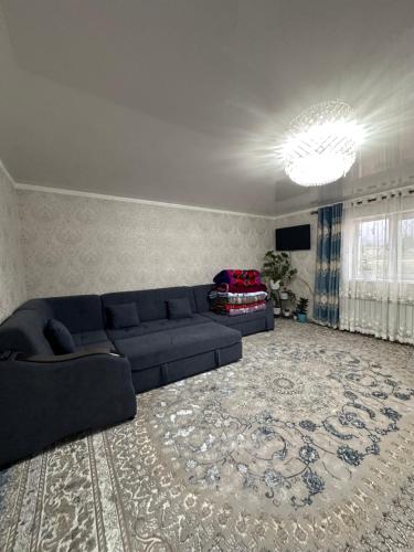 a living room with a blue couch and a rug at Дом для отдыха in Pokrovka