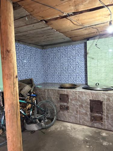 a kitchen with a counter and a bike in a room at Дом для отдыха in Pokrovka