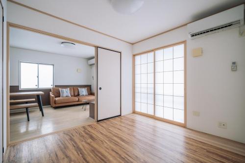 an empty living room with a couch and a table at Comfort Miyabi -4号棟 in Yomitan