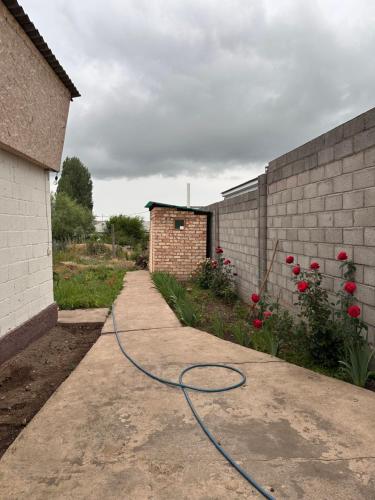 a hose on a sidewalk next to a brick wall at Дом для отдыха in Pokrovka