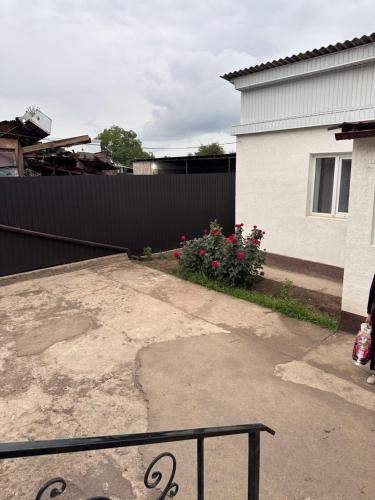 a backyard of a house with a fence and flowers at Дом для отдыха in Pokrovka