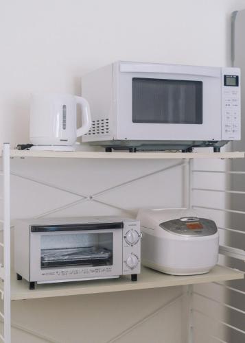 a microwave and a toaster oven on a shelf at Comfort Miyabi -4号棟 in Yomitan