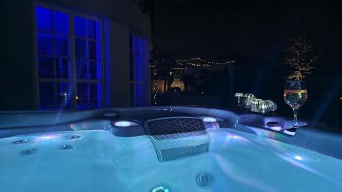 a jacuzzi tub with a glass of wine at Strefa ZEN z Jacuzzi i Basenem in Żerniki Wrocławskie