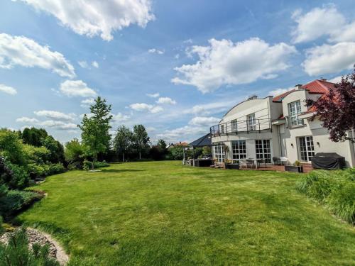 a large yard in front of a white house at Strefa ZEN z Jacuzzi i Basenem in Żerniki Wrocławskie