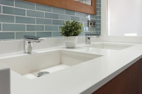 a white sink in a bathroom with a potted plant at Ag Bermudas Deluxe in Gandía