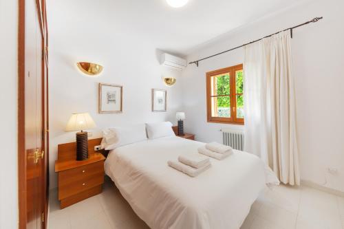 Un dormitorio con una cama blanca con dos toallas encima. en Casa Felix, en Palma de Mallorca