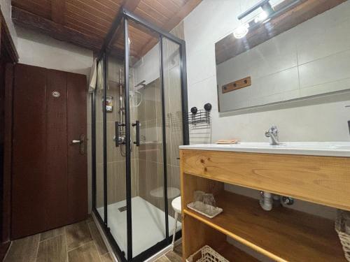 a bathroom with a glass shower and a sink at Albergue Rectoral de Romean in Lugo