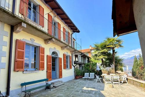 a building with a bench and a table and chairs at Villa Ca' Vegia in Stresa