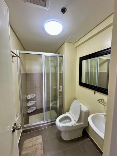 a bathroom with a toilet and a shower and a sink at Tagaytay Staycation - Balaico 2 balconies Taal View 2BR in Tagaytay