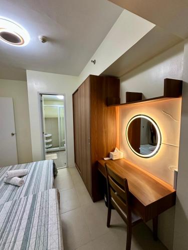 a bedroom with a desk and a bed and a mirror at Tagaytay Staycation - Balaico 2 balconies Taal View 2BR in Tagaytay