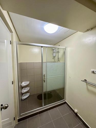 a shower with a glass door in a bathroom at Tagaytay Staycation - Balaico 2 balconies Taal View 2BR in Tagaytay