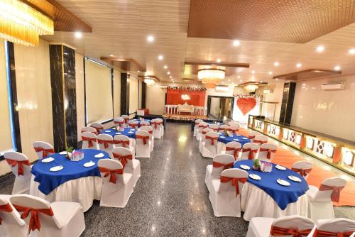 a banquet hall with blue and white tables and chairs at Foxoso Fiori Hotel in Jaipur